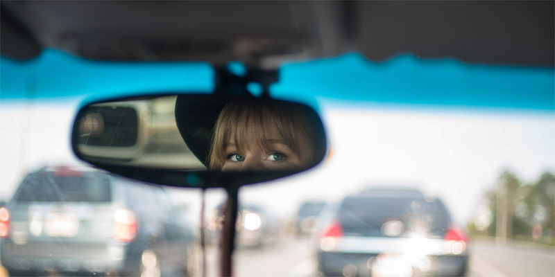 Chica mirando por el retrovisor