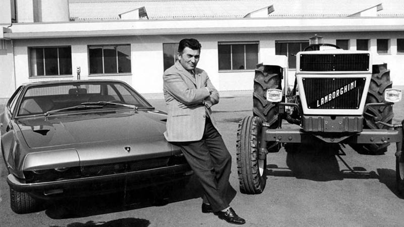 Ferruccio Lamborghini posando con un tractor y un coche de su marca