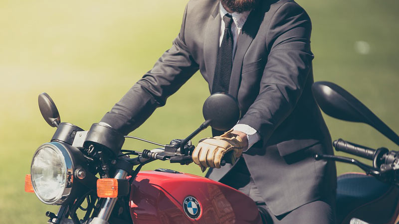 Hombre en traje montando en una moto roja de BMW