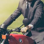 Hombre en traje montando en una moto roja de BMW