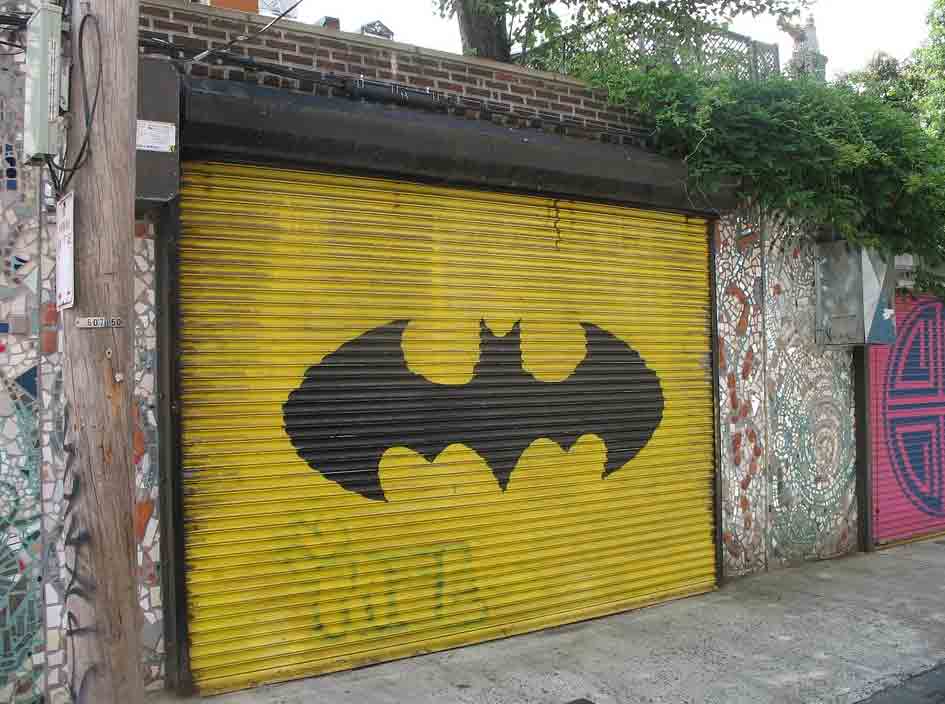 puerta de garaje amarilla con el emblema de batman en negro