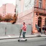 chico circulando por la ciudad con un patinete eléctrico